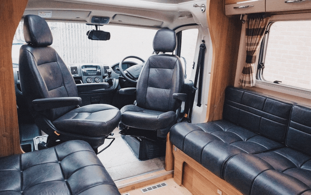 GIF of a motorhome interior, furniture reupholstered in a dark grey leather